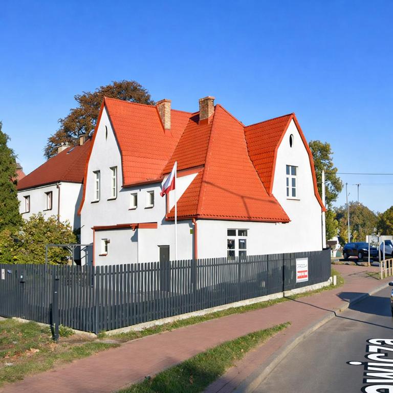 a large white house with an orange roof at Apartamenty u Antka in Nowe Miasto Lubawskie