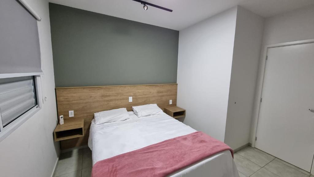 a small bedroom with a bed with a red blanket at Casa Holambra Van den Broek in Holambra
