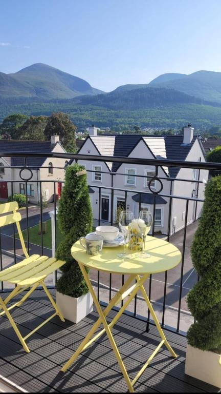 a yellow table and chairs on a balcony at The Mourne Nest in Newcastle