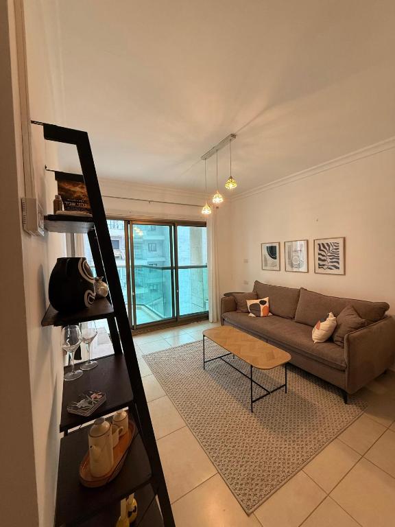 a living room with a couch and a table at נוף ראשון לים in Ashkelon