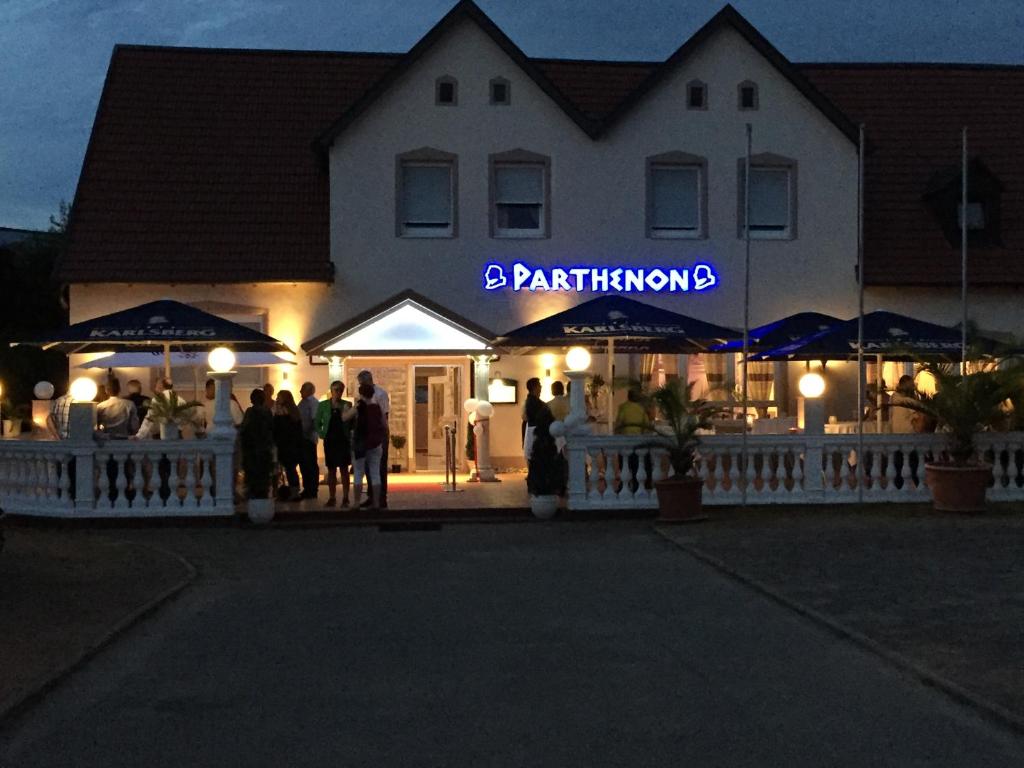 un groupe de personnes debout à l'extérieur d'un bâtiment dans l'établissement Hotel Restaurant Parthenon, à Otterbach