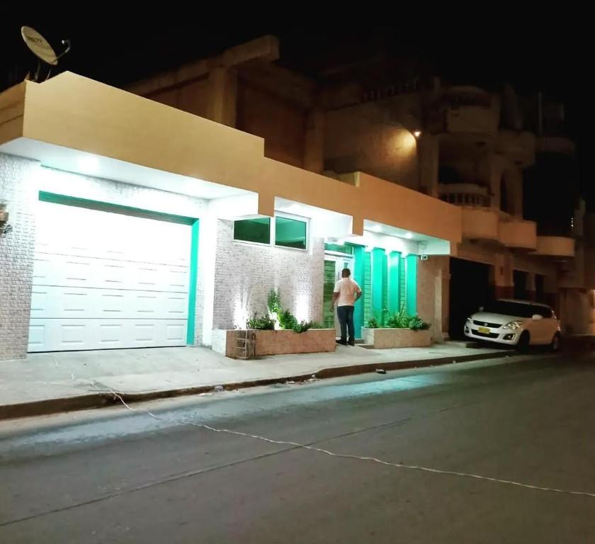 a man standing in front of a garage at night at Hotel Aquamarina Maicao in Maicao