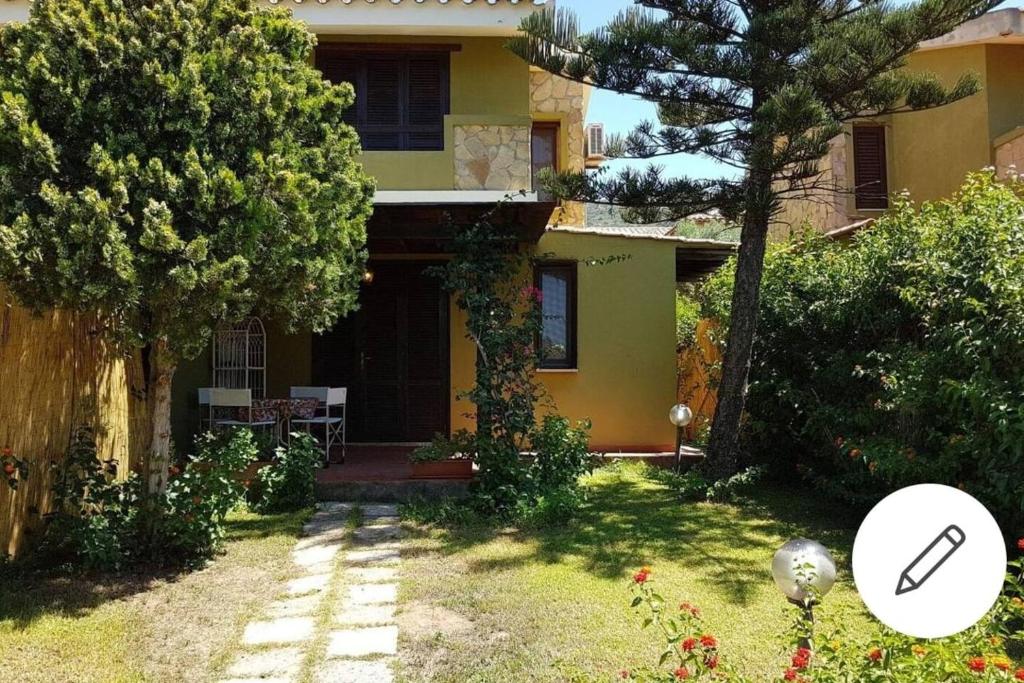a yellow house with a garden and a magnifying glass at Villa Celeste in Torre delle Stelle