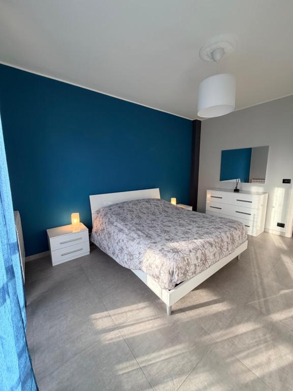 a bedroom with a bed and a blue wall at Ladybug in Canale