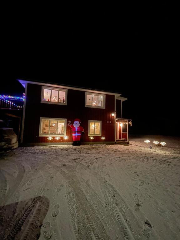 a santa claus standing in front of a house at night at Villa nära Järvsö in Järvsö