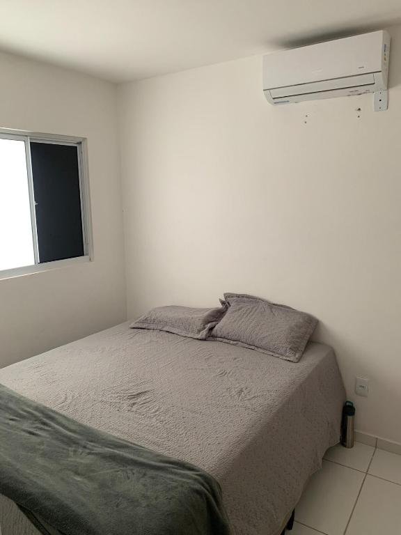 a white bedroom with a bed and a window at Casa condominio Reserva do Delta 07 in Parnaíba