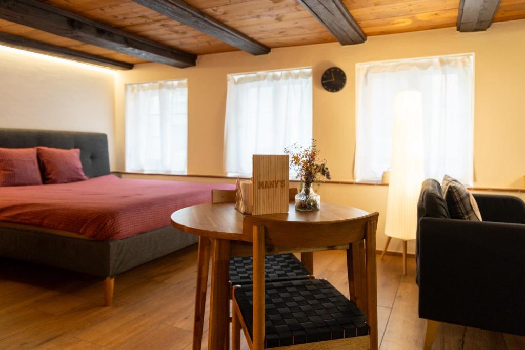 a room with a bed and a table and a bed and windows at MANY'S historical city central APARTMENTS in Zurich