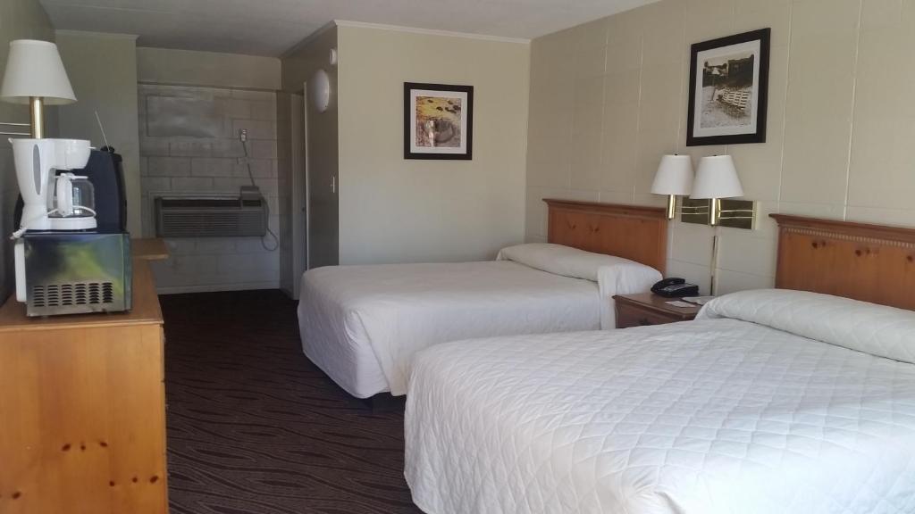 a hotel room with two beds and a television at Admiral Motor Inn in Myrtle Beach