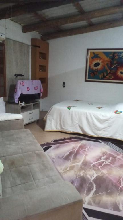 a room with two beds and a suitcase on the floor at Chalé da Janete in Capão da Canoa