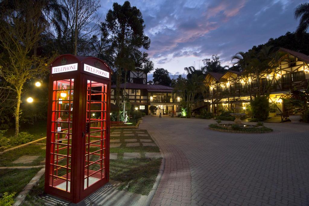 a red phone booth in front of a building at Hotel Britannia in Penedo