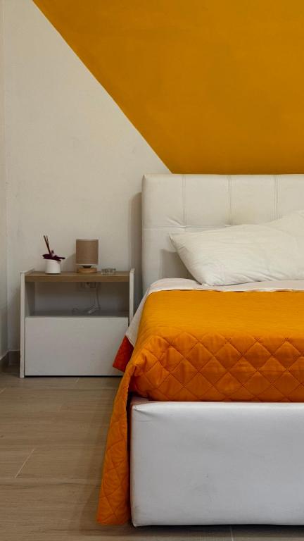a bedroom with an orange and white bed and a desk at Lumèra Holiday Home in Pizzo