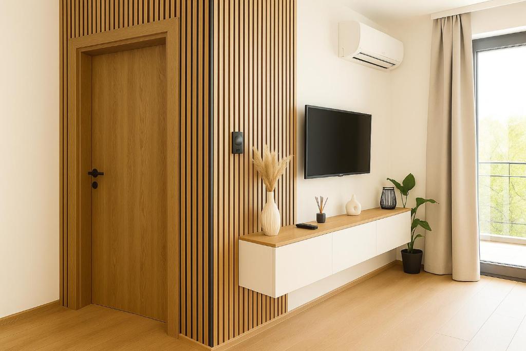 a living room with a television on a wall at RIVER LuX in Veliko Gradište