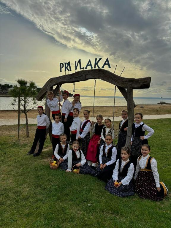 a group of children posing for a picture under a sign at Tina in Privlaka