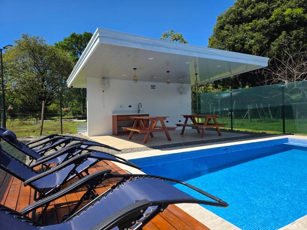 a house with a swimming pool and a table at The Palm at Life's a Beach in Uvita