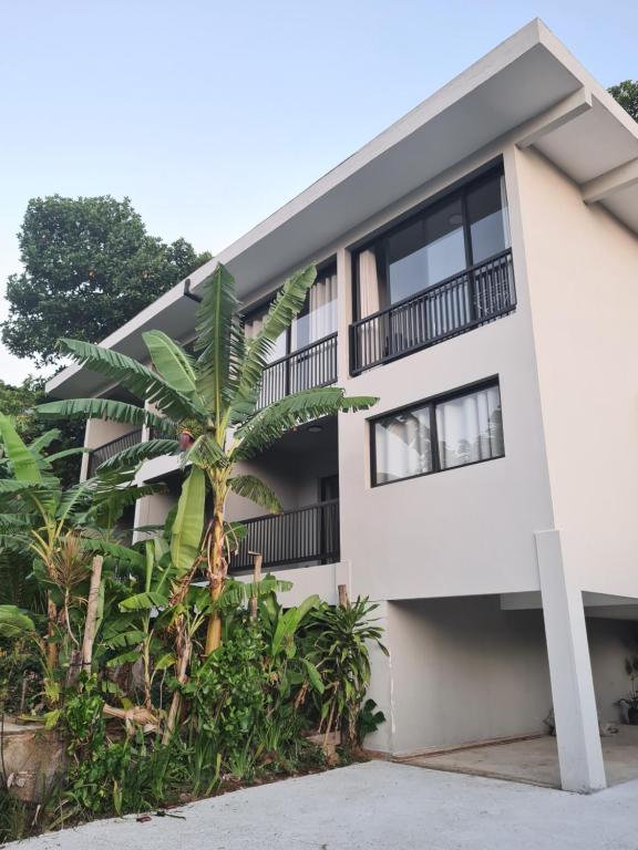 a building with a palm tree in front of it at Pousada Villa Julião in Ilhabela