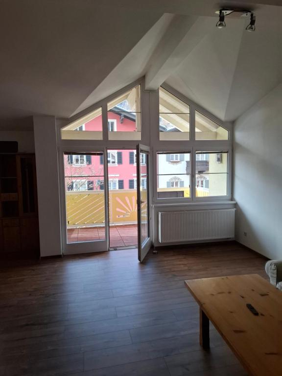 an empty room with large windows and a wooden table at Haus Nadegger in Werfen