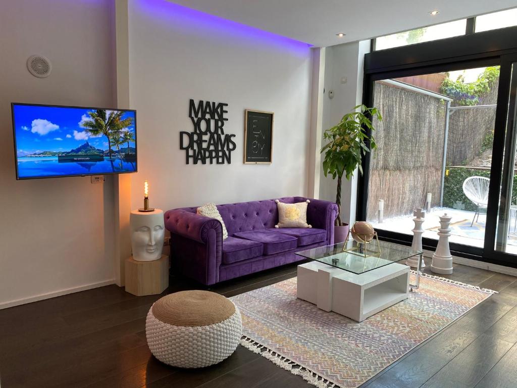 a living room with a purple couch and a tv at Loft Elegante Norte de Madrid in San Sebastián de los Reyes