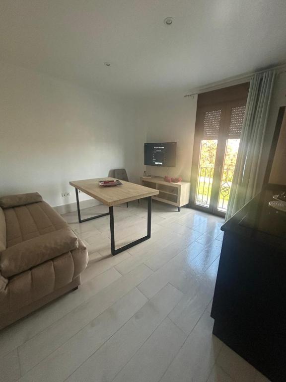 a living room with a table and a couch at Apartamentos luz de Doñana 1 in Moguer