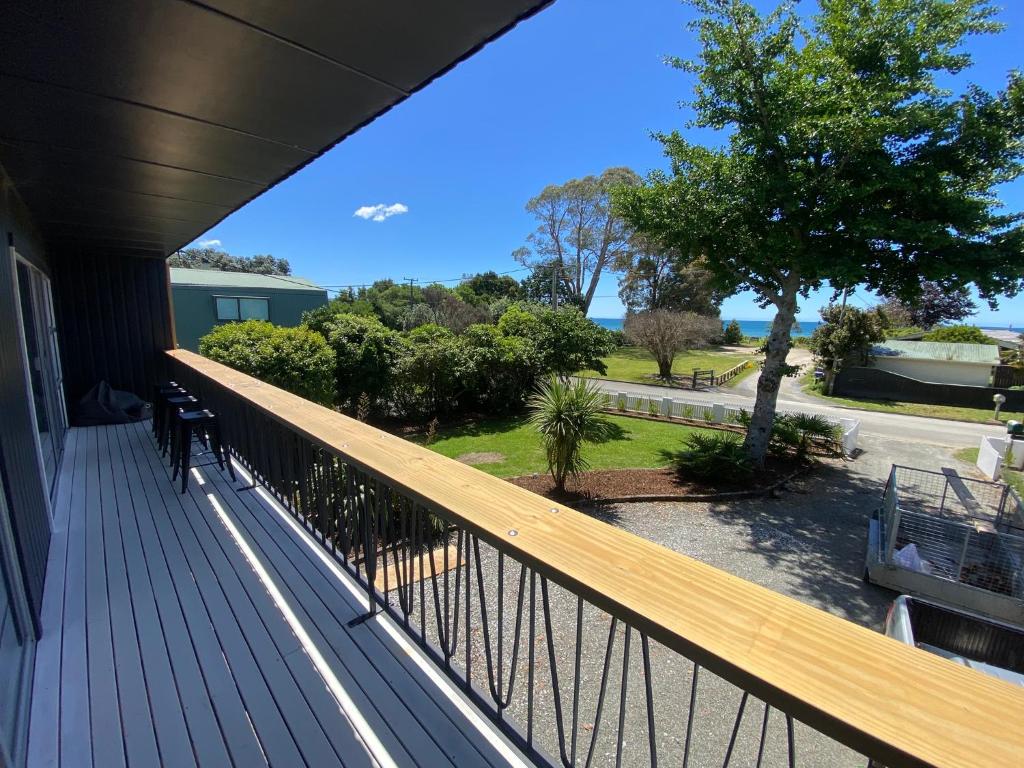 a balcony of a house with a view of the ocean at The Rock House, Patons Rock in Rangihaeata