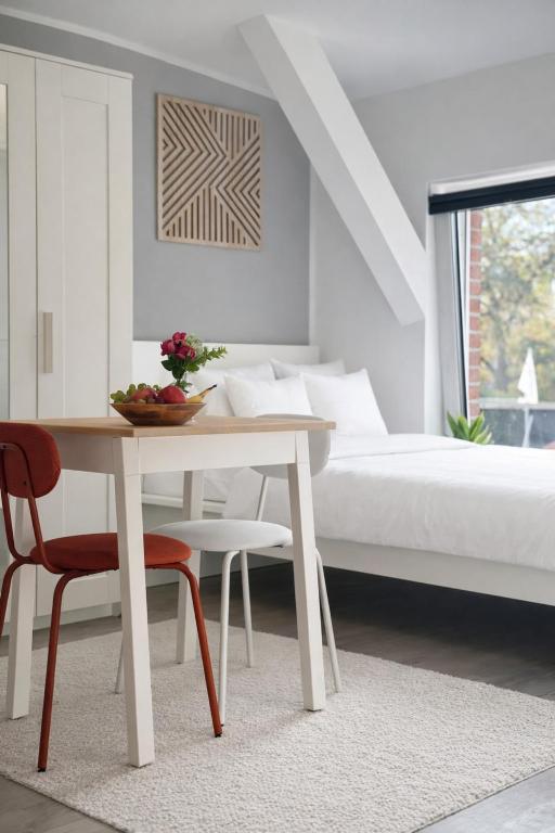 a white bedroom with a table and a bed at Studio Apartment 1- Komfort & Günstig in Berlin