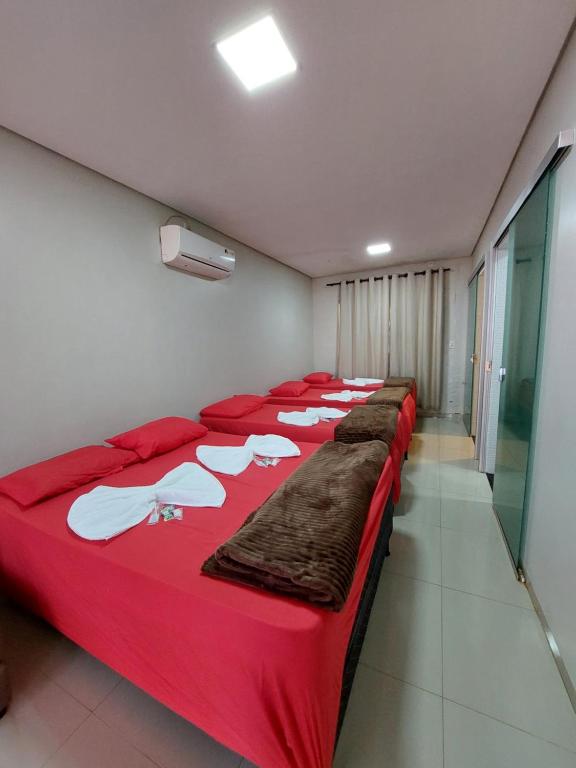 a row of beds lined up in a room at Suíte Família 5 pessoas - Queen's Hotel in Formosa