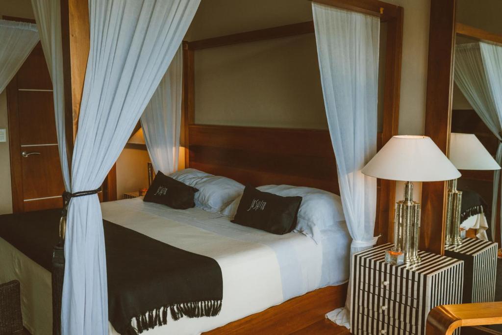 a bedroom with a bed with blue curtains at Coral Breeze Retreat in Balcheil