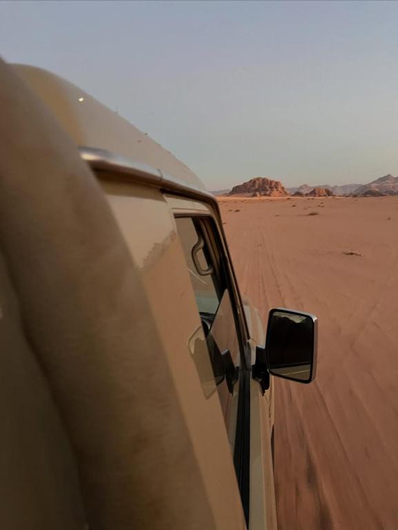 a car parked in the desert with its door open at Star Gate Camp in Wadi Rum