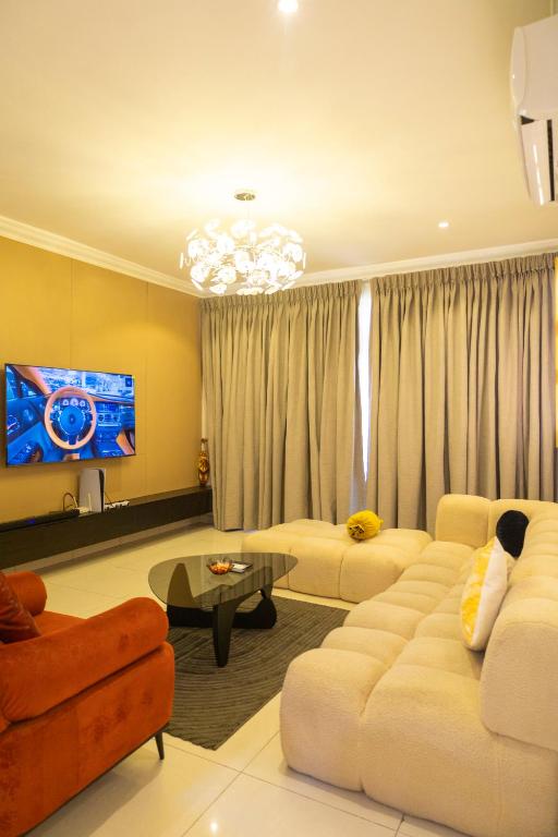 a living room with two couches and a tv at Ashtead Haven in Ikate
