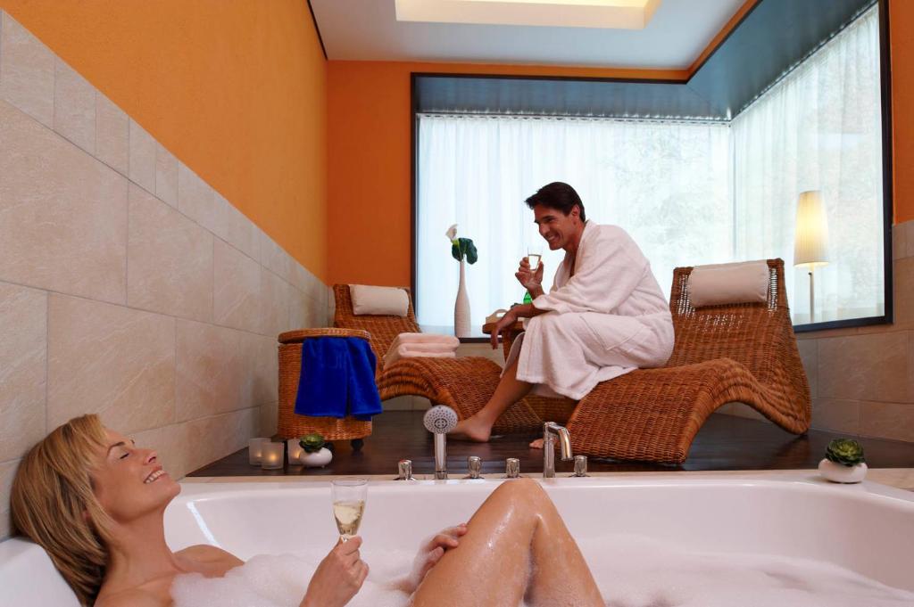 un hombre y una mujer en una bañera en Hotel Residenz, en Bad Bertrich