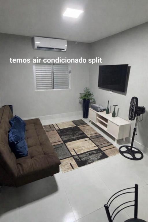 a living room with a couch and a flat screen tv at Conforto setor Oeste garagem 505 in Goiânia