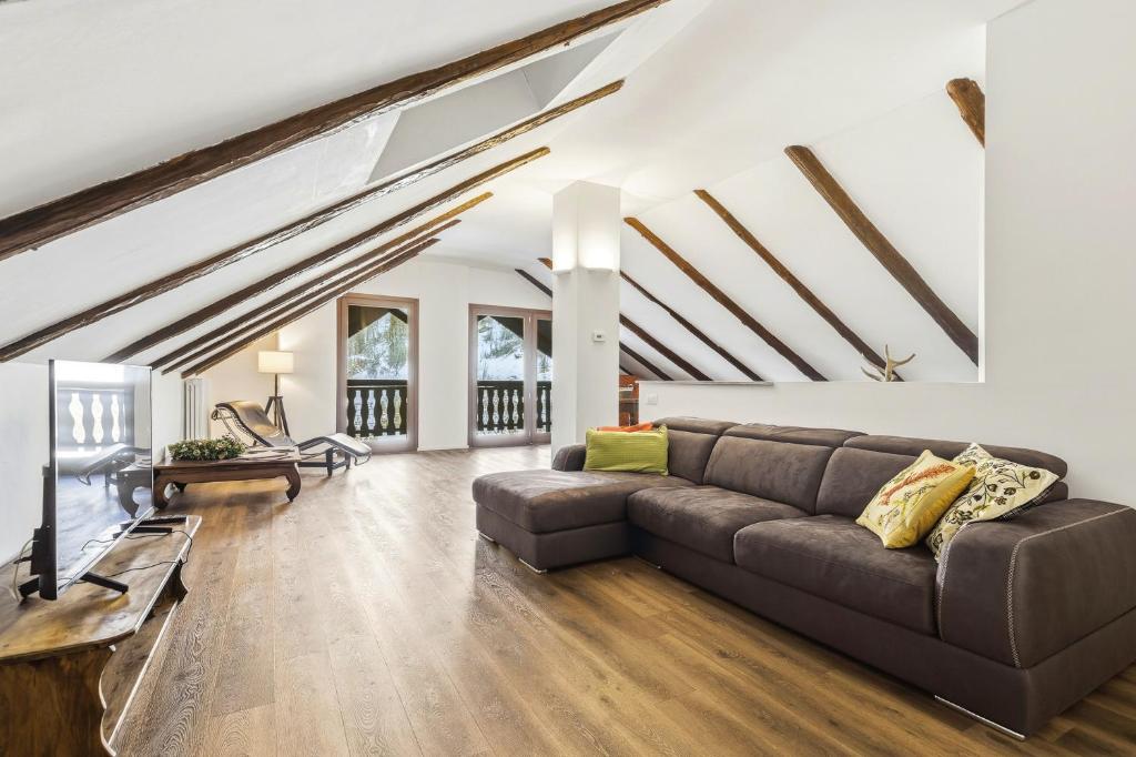 a living room with a couch and a tv at Hostdomus - Inside Alps Suite in Cesana Torinese