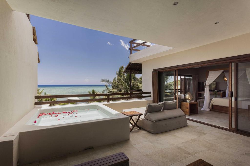 a living room with a tub and a view of the ocean at Sunset Crown Suite in Balcheil