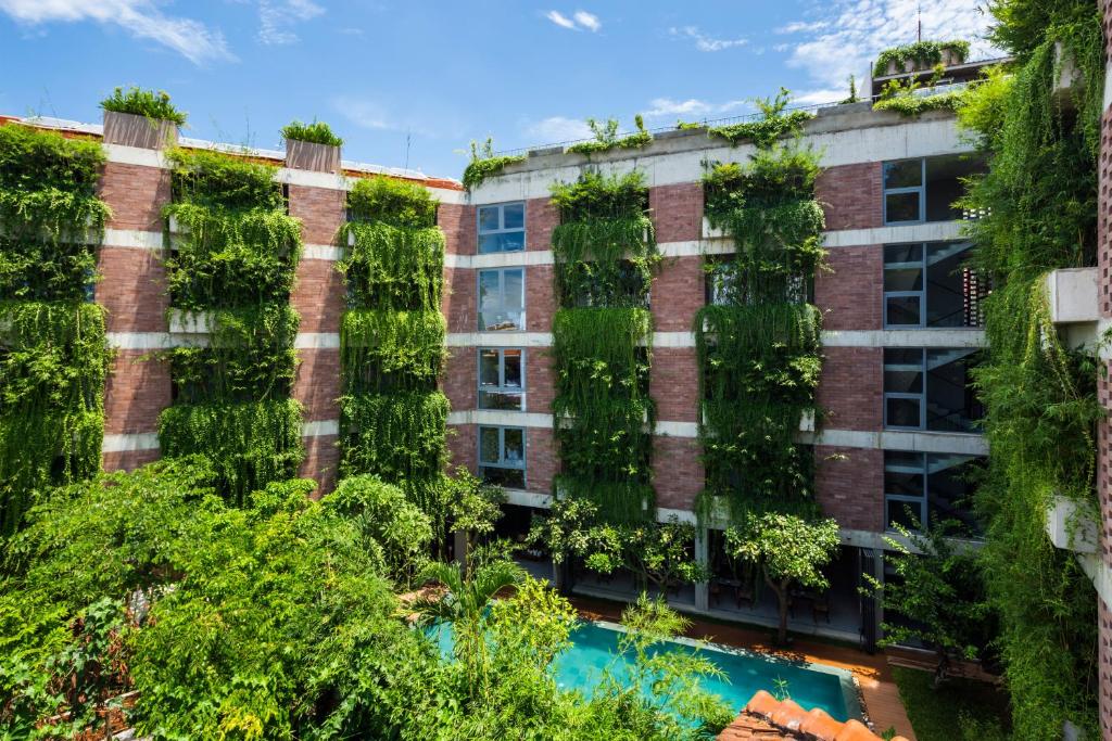 un edificio de apartamentos con plantas a un lado en Mulberry Collection Silk Eco, en Hoi An