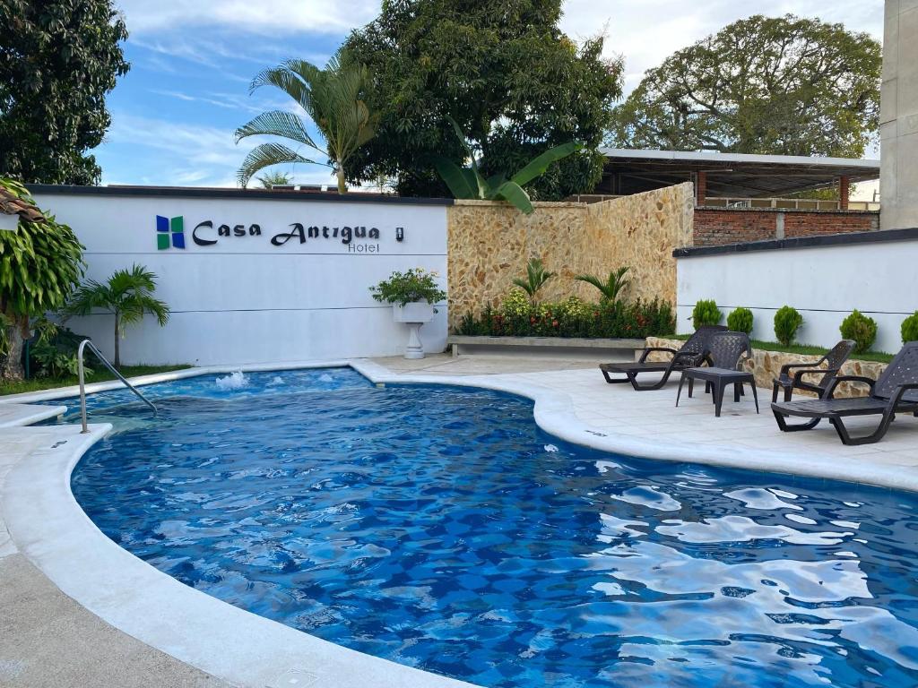 a pool with blue water in front of a building at Hotel Casa Antigua Buga in Buga
