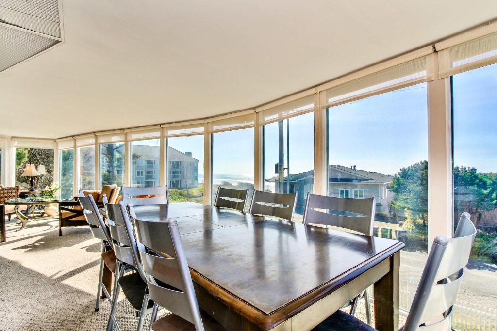 a dining room with a table and chairs and windows at Neptune's Trident in Lincoln Beach
