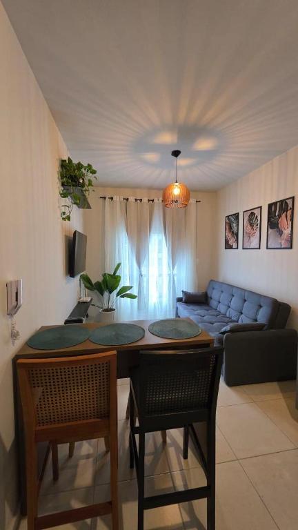 a living room with a table and chairs and a couch at Praia e Cambirela in Palhoça