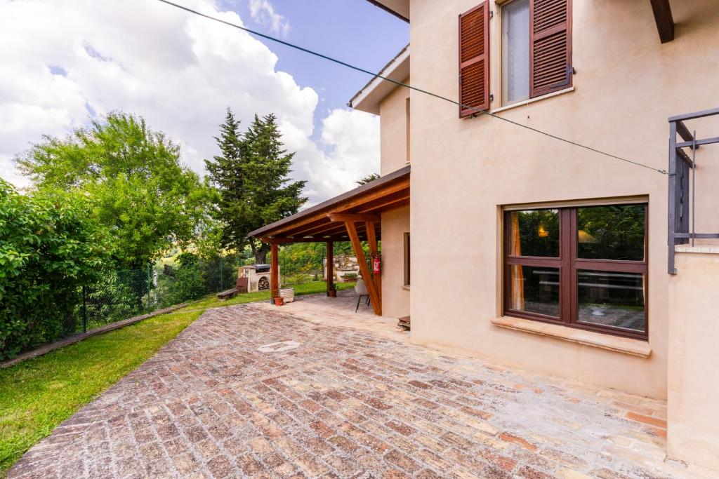 a house with a brick driveway next to a building at house Al Cascinale in San Severino Marche