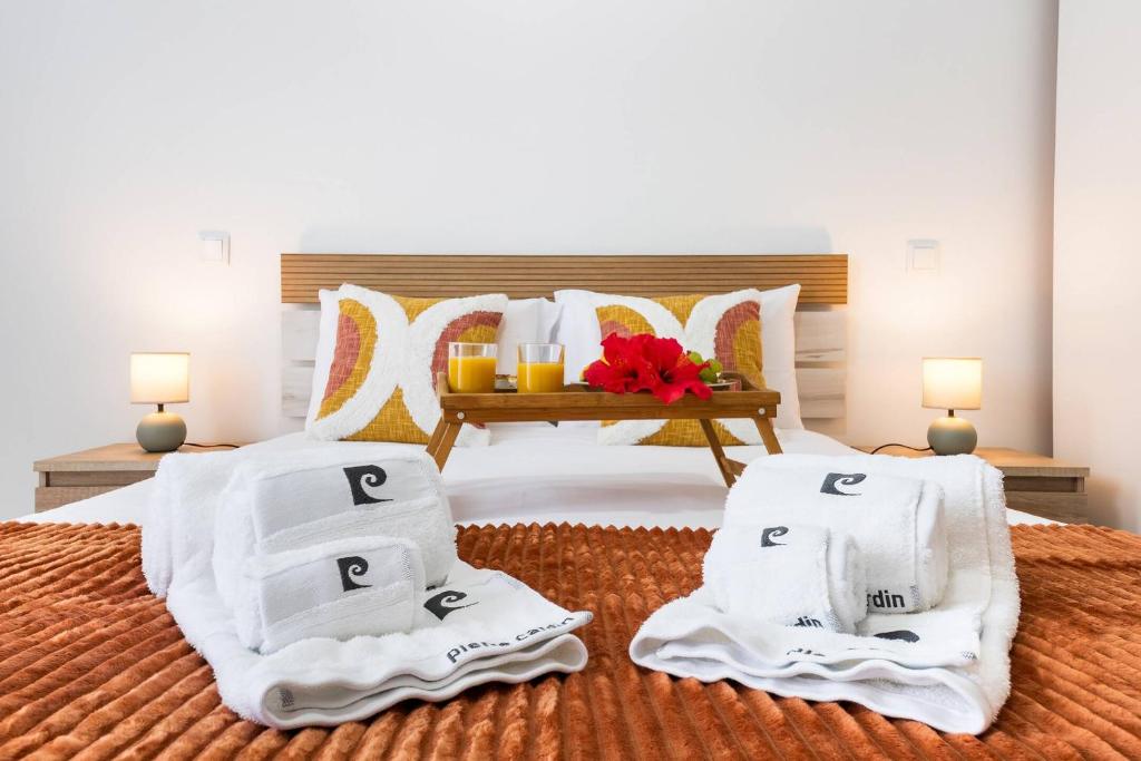 a bedroom with a bed with white towels and a table at Sol Blessing by GALMI in Ponta do Sol