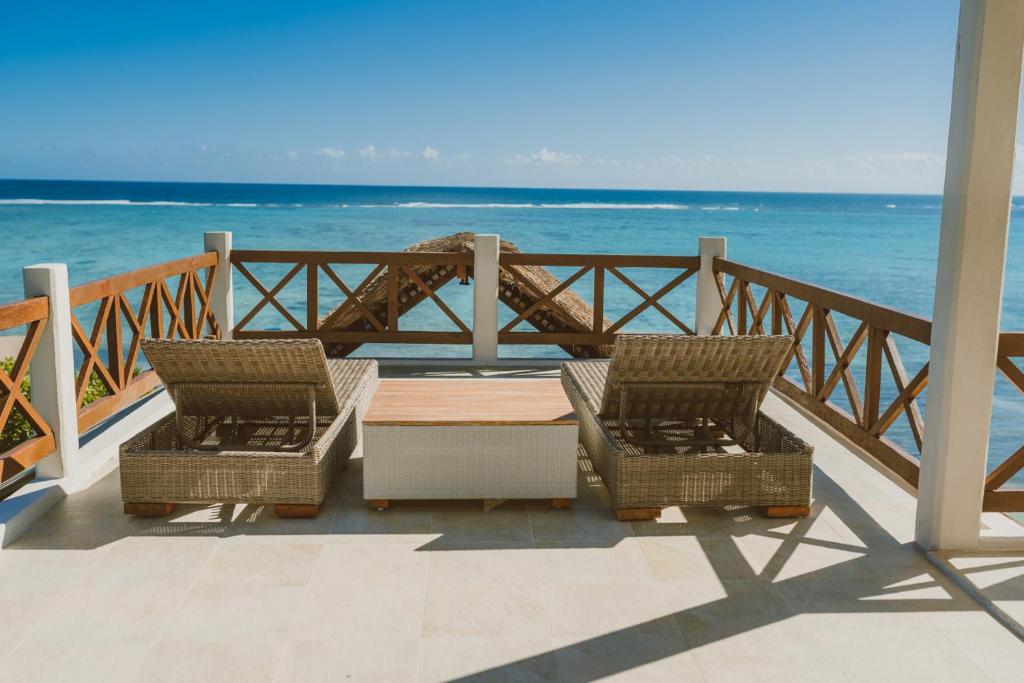 um pátio com duas cadeiras e uma mesa e o oceano em Celestial Penthouse em Balcheil