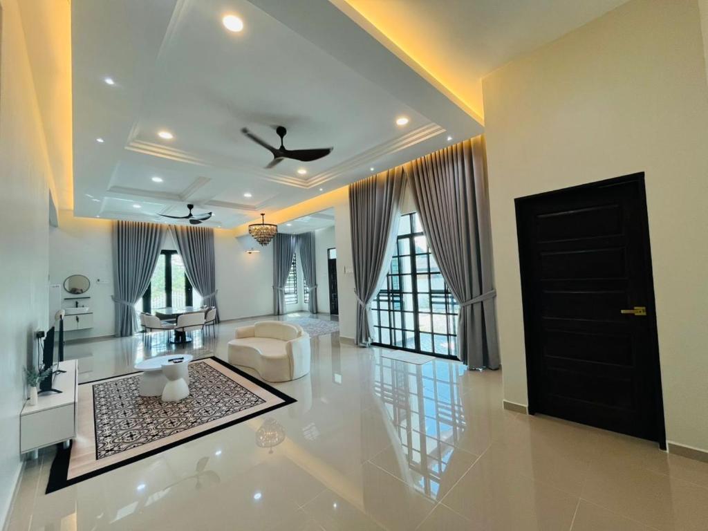 a living room with a black door and a ceiling at Husna WhiteStay Modern Luxury Family Home spacious 1700sqft Gated Parking in Bukit Payong