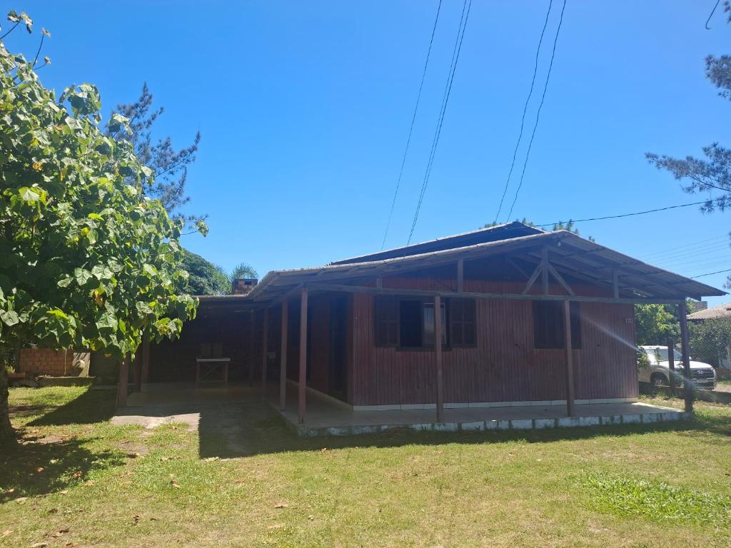 a small house with a roof in a yard at Casa da praia sulmar in Balneário Gaivotas