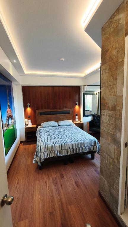 a bedroom with a bed and a wooden floor at HOTEL Y MOTEL SAVOY - Santiago in Santiago