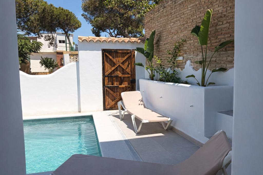 a patio with a chair and a swimming pool at Villas con piscina en Punta Umbría by Villamya in Punta Umbría