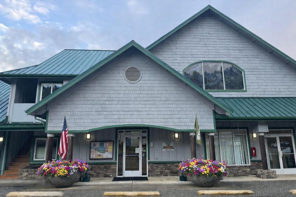 a building with a flag and flowers in front of it at The Waterfront at Potlatch in Shelton