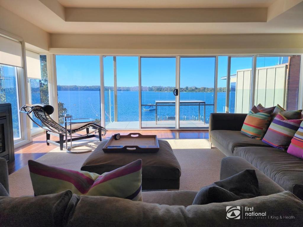a living room with a large view of the water at Bay Suite - Waterfront Apartment in Metung in Metung