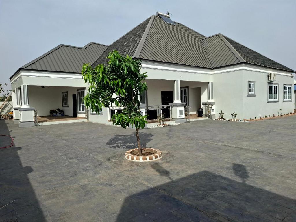 a large white house with a tree in a courtyard at Pelican VVIP Villa in Wa