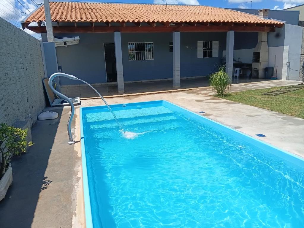 a swimming pool in front of a house at Recanto do sol in Brotas