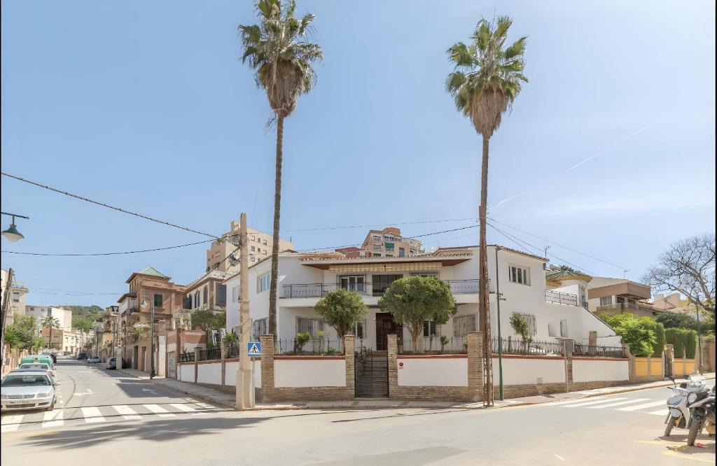 a street with two palm trees and a house at AYZ Silvela - Auto check-in property in Málaga