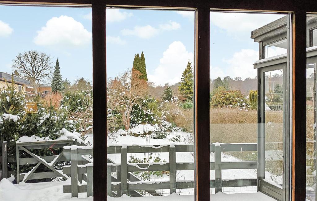 Blick aus einem Fenster auf einen Garten im Schnee in der Unterkunft Testhuset in Bøtø By