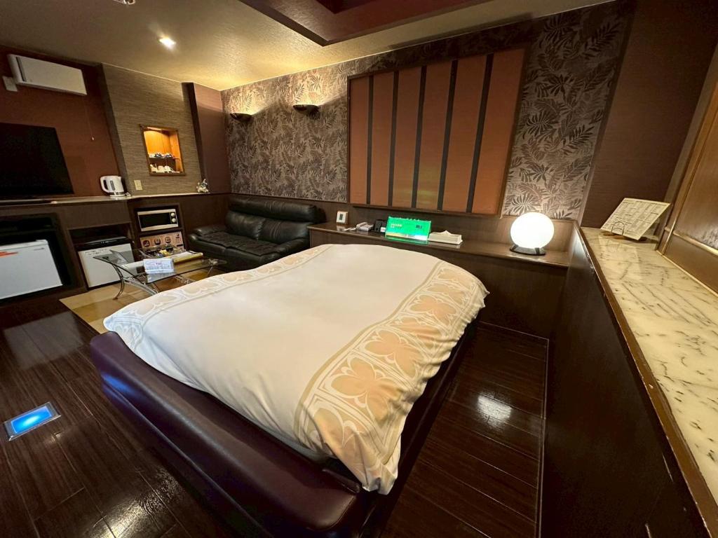 a bedroom with a large bed and a couch at ホテルスター in Iwaki